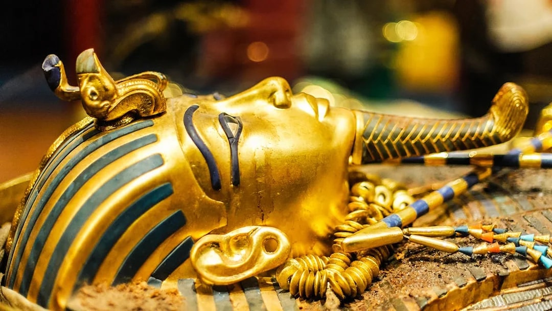 Tutankhamun's golden mask with intricate blue and gold detailing.