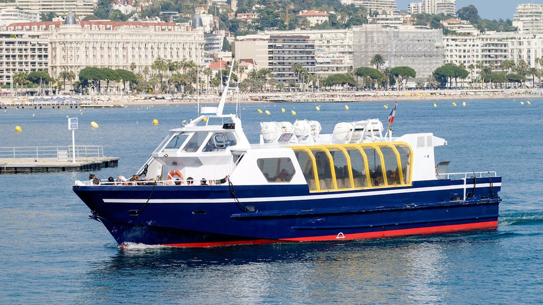 Ferry departing Cannes for Ste. Marguerite Island with cityscape in background.