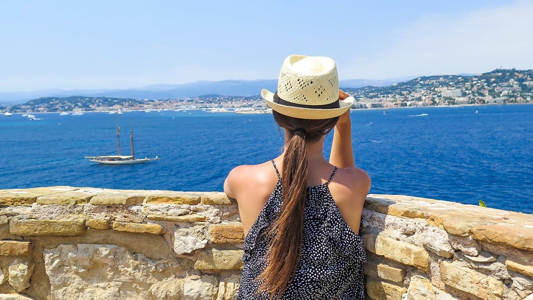 Woman overlooking the sea from Ste. Marguerite Island with Cannes in the background.
