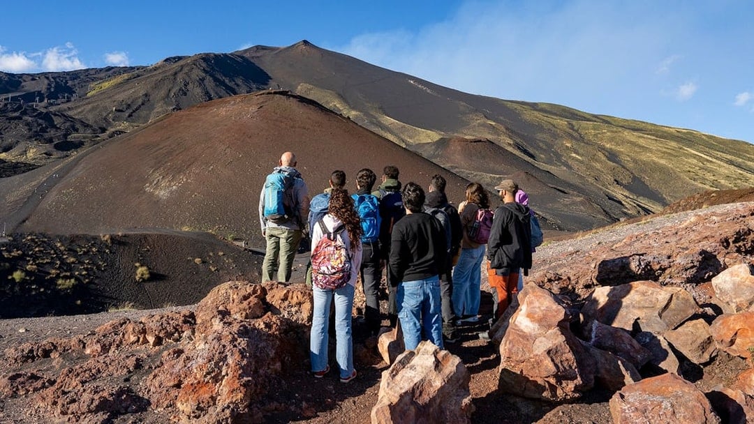 Group of tourists on a guided tour of Mount Etna's volcanic landscape in Catania.
