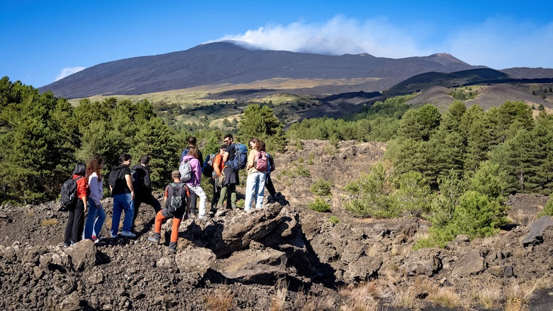 Group of hikers exploring volcanic landscape on Mount Etna during Catania morning tour.