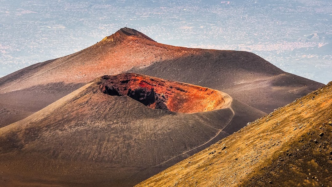 Mount Etna crater with surrounding landscape on a guided afternoon tour.