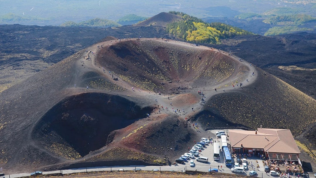 Tourists exploring volcanic craters on Mount Etna in Catania, Sicily.