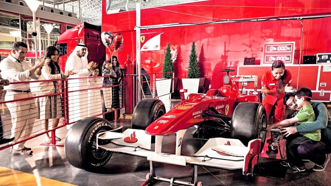 Visitors at Ferrari World Abu Dhabi interacting with a Formula 1 car exhibit.
