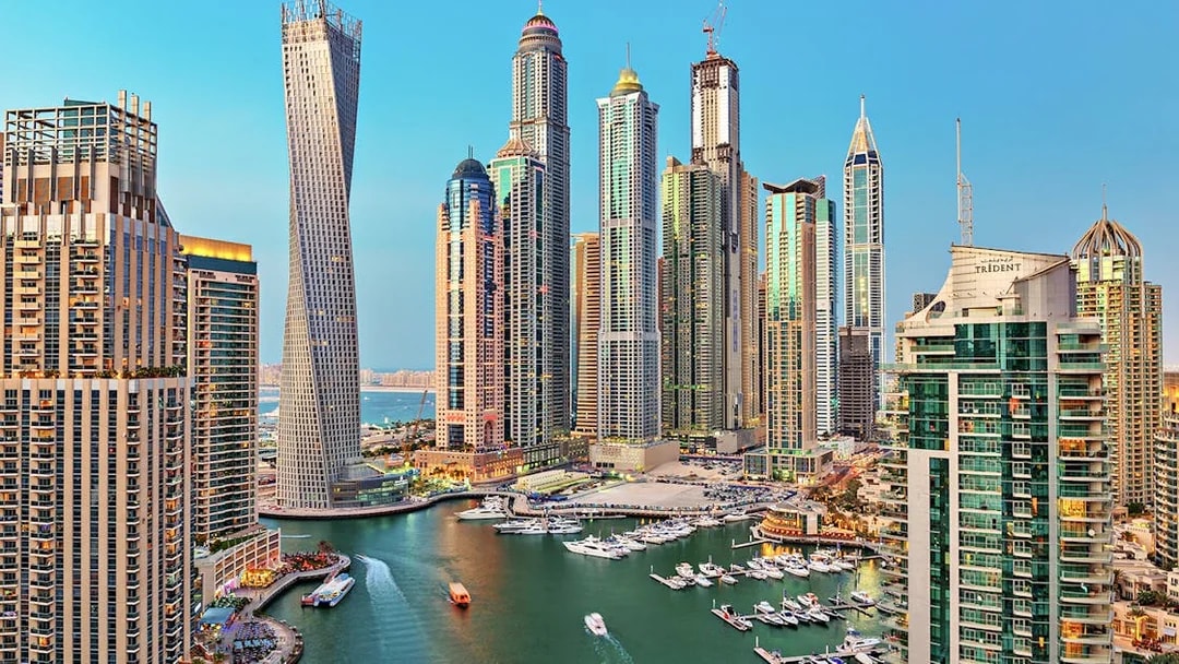 Aerial view of Dubai Marina with skyscrapers and yachts in the daytime.