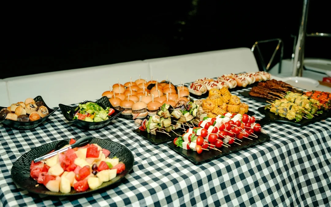 Buffet spread on Dubai Harbour luxury yacht tour with sliders, skewers, and salads.