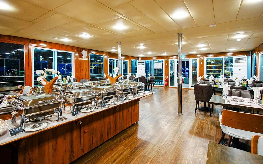 Dinning area setup on Alexandra Sea Lounge Dhow Cruise with buffet and seating.
