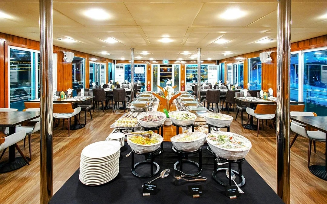 Dining setup on Alexandra Sea Lounge Dhow Cruise with buffet and seating area.