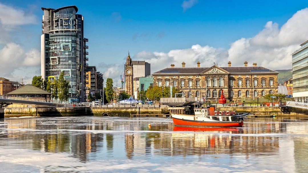 Belfast cityscape with Albert Clock and waterfront buildings.