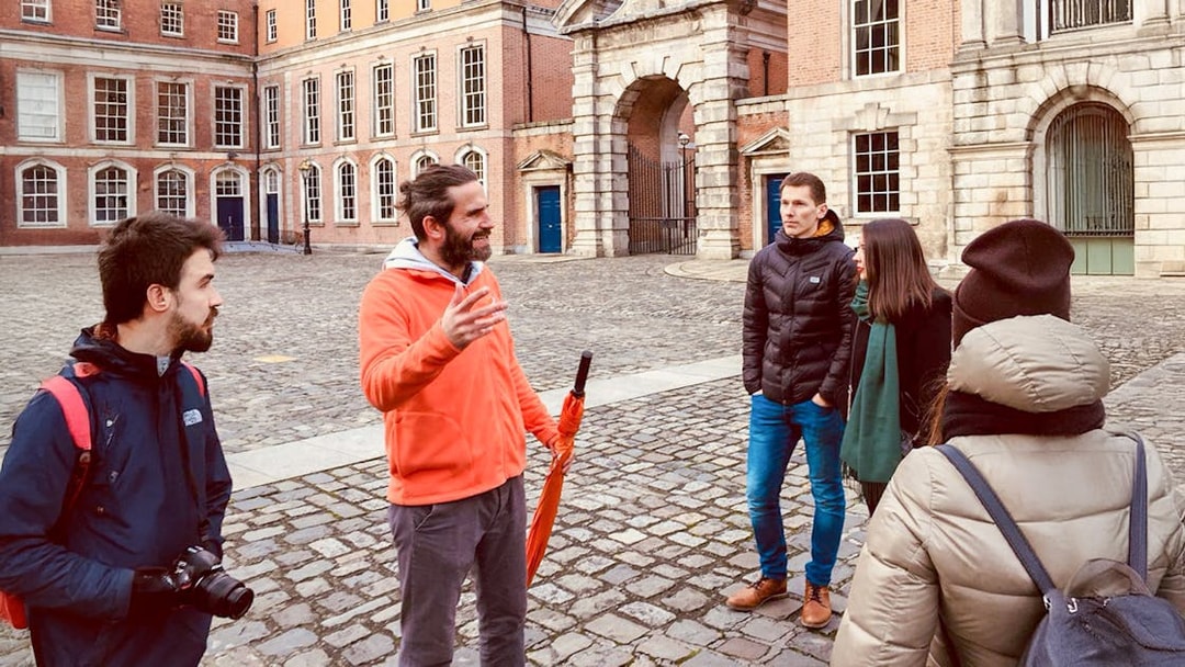 Tour guide with group in a historic courtyard, discussing local architecture.