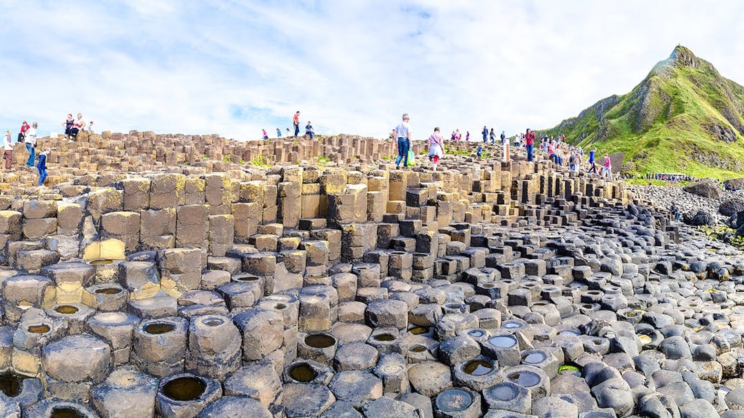 Visitors exploring basalt columns at Giant's Causeway, Northern Ireland.