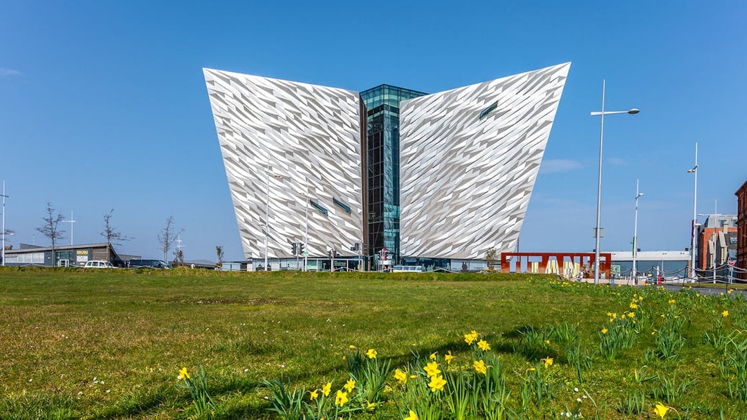 Titanic Belfast museum with daffodils in foreground, part of Dublin tour.