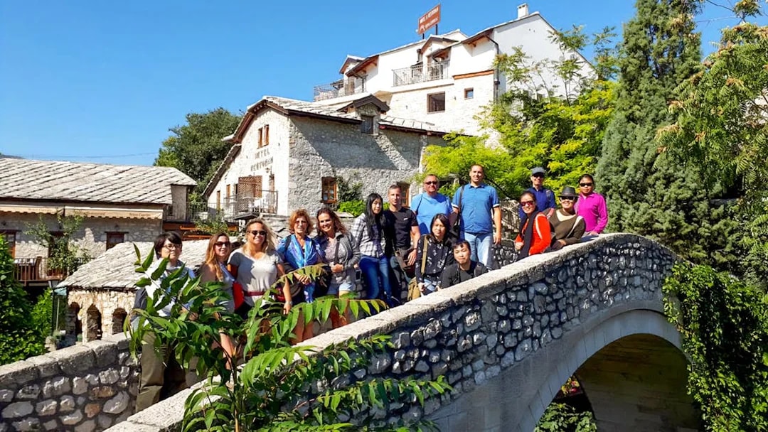 Tourists exploring Kriva ćuprija bridge in Mostar