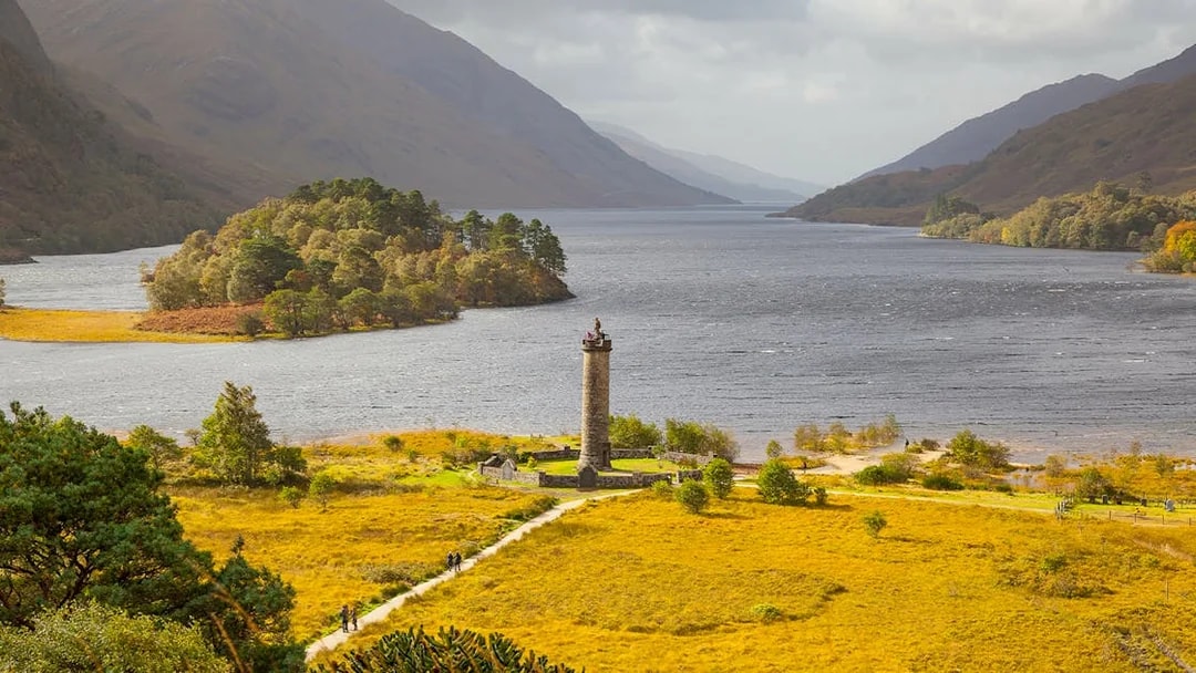 Glenfinnan Monument overlooking Loch Shiel with surrounding hills in Scotland.