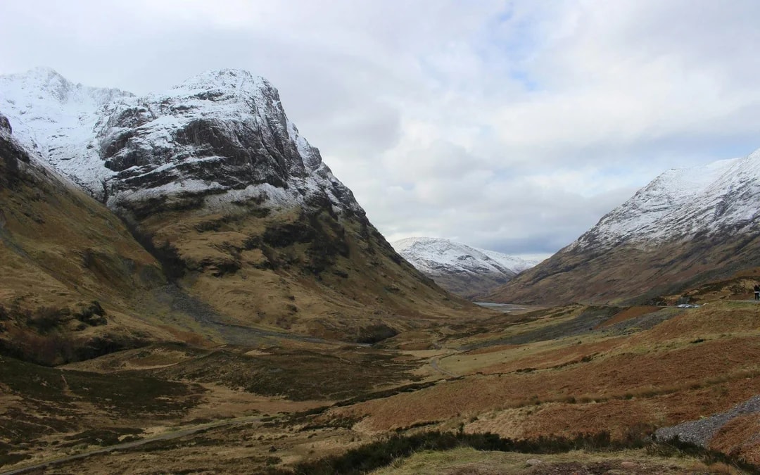 Snow-capped mountains in Glencoe, Scotland, with a valley view.