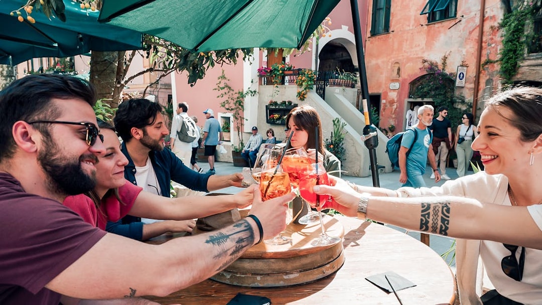 Group enjoying drinks at an outdoor café in Cinque Terre, Italy.