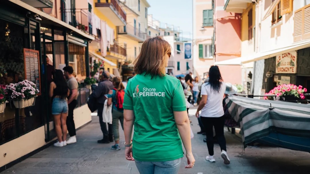 Tourists exploring a vibrant street in Cinque Terre, Italy.