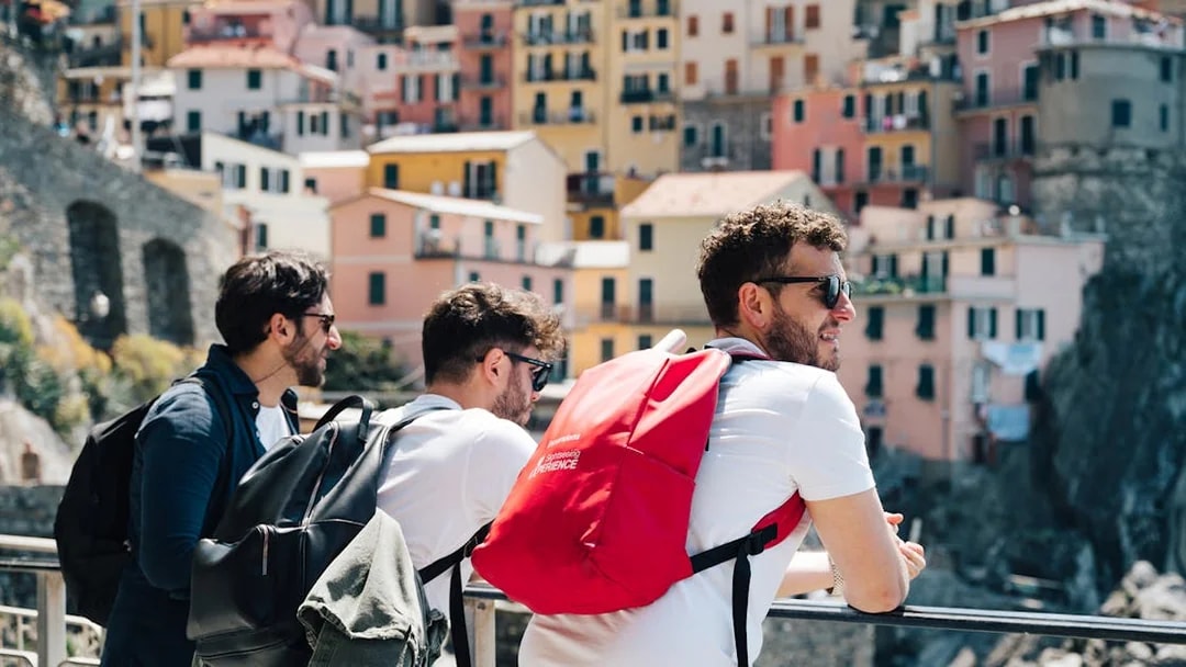 Tourists enjoying the view of colorful buildings in Cinque Terre, Italy.