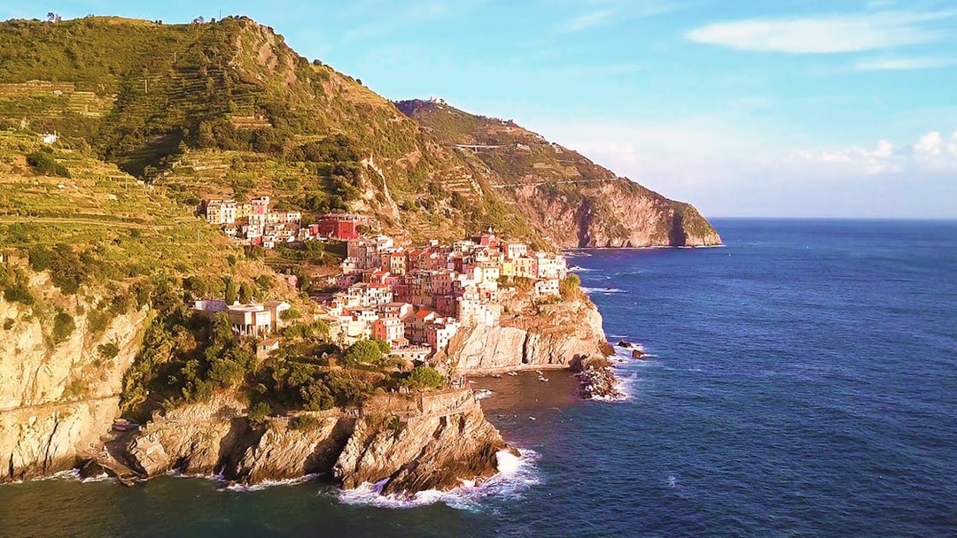 Cinque Terre coastal village view with colorful buildings on cliffs by the sea.