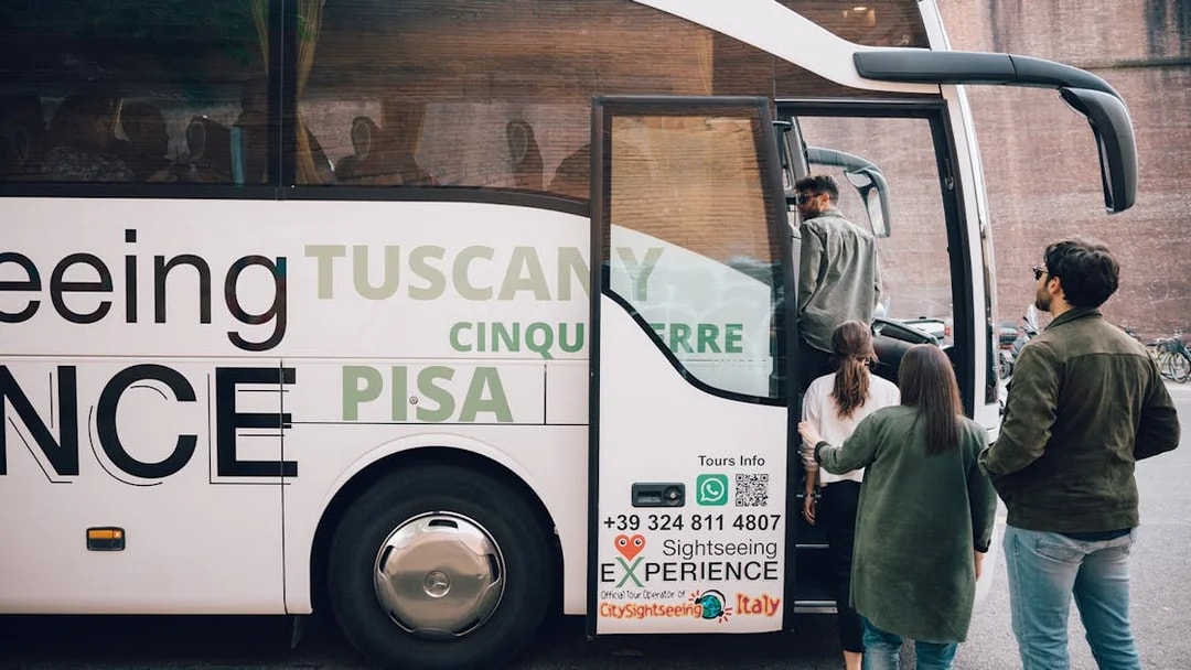 Tourists boarding a sightseeing bus for a day trip to Cinque Terre, Italy.