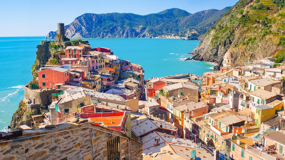 Colorful houses on a cliffside in Vernazza, Cinque Terre, overlooking the Ligurian Sea.