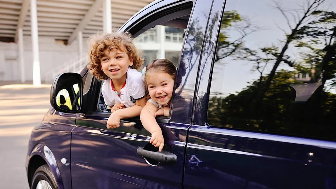 Children smiling from a car window during a Cinque Terre tour from Florence.
