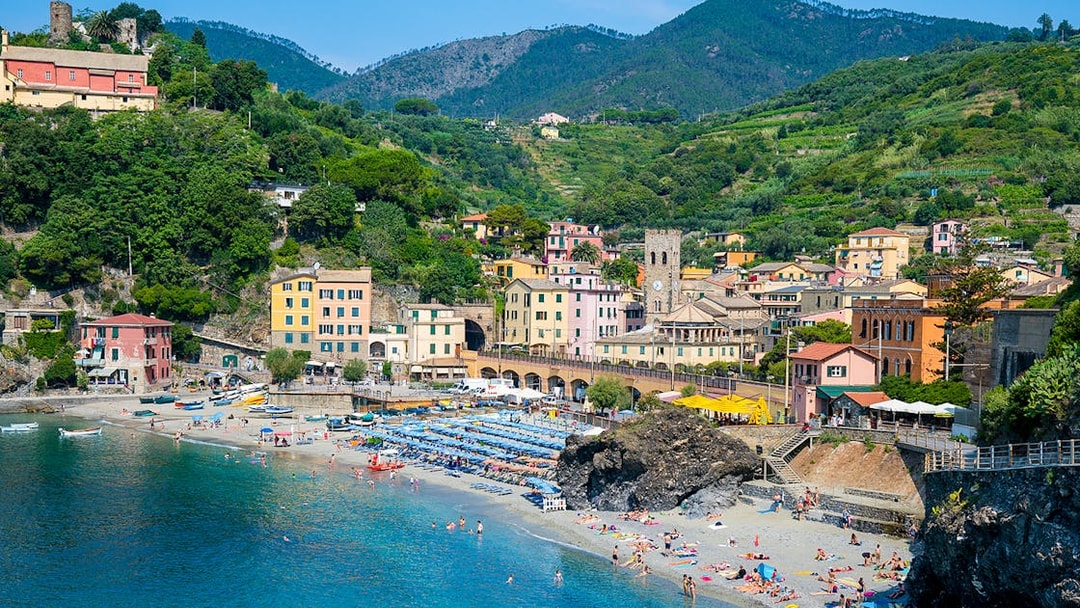 Monterosso beach with colorful buildings and hills in Cinque Terre, Italy.
