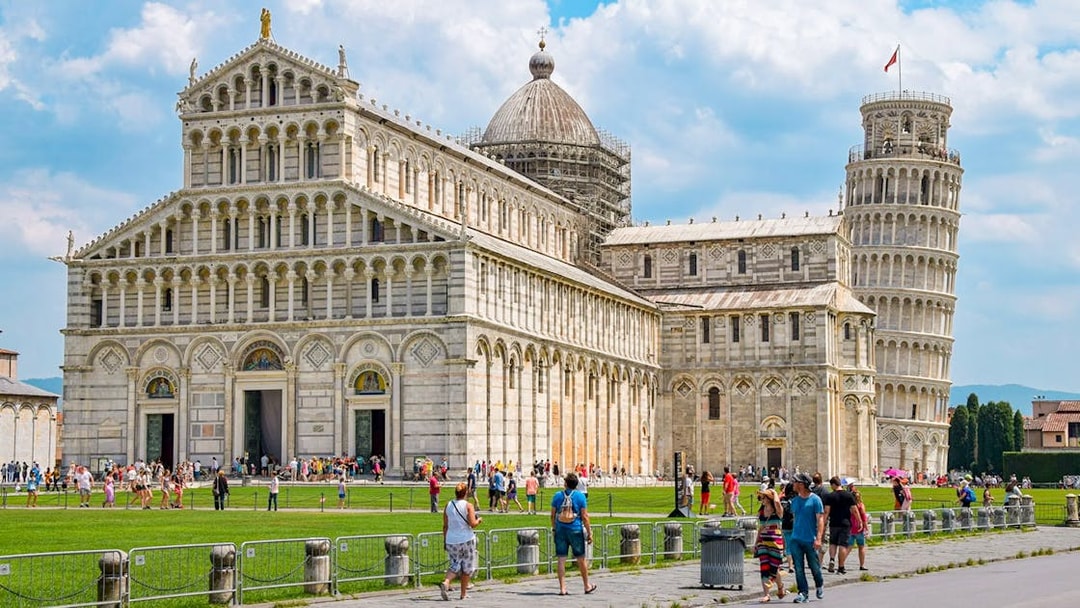 Cathedral and Leaning Tower of Pisa with tourists in the foreground.