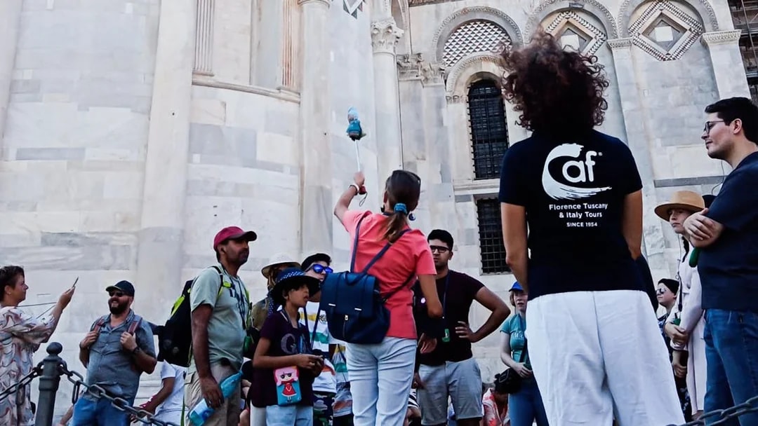 Tour group in Pisa with guide near cathedral, part of Florence to Pisa tour.