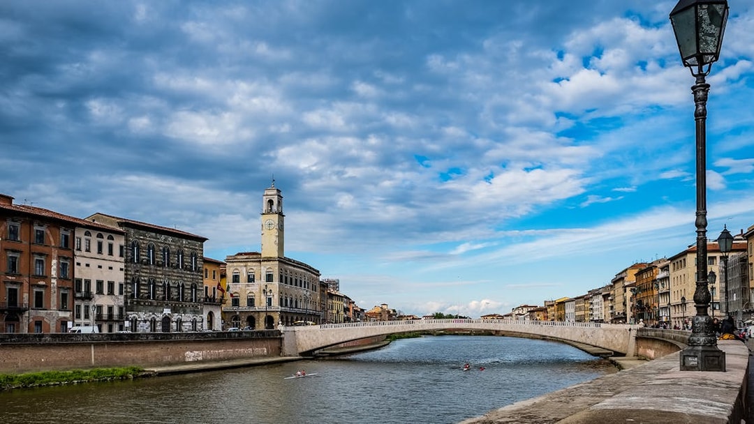 Pisa cityscape with Arno River and historic buildings, viewed during a guided tour from Florence.