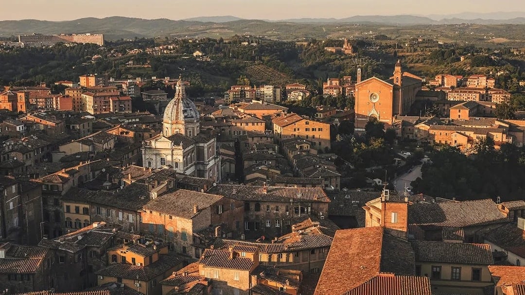 Aerial view of Siena's historic rooftops and cathedral in Tuscany, Italy.