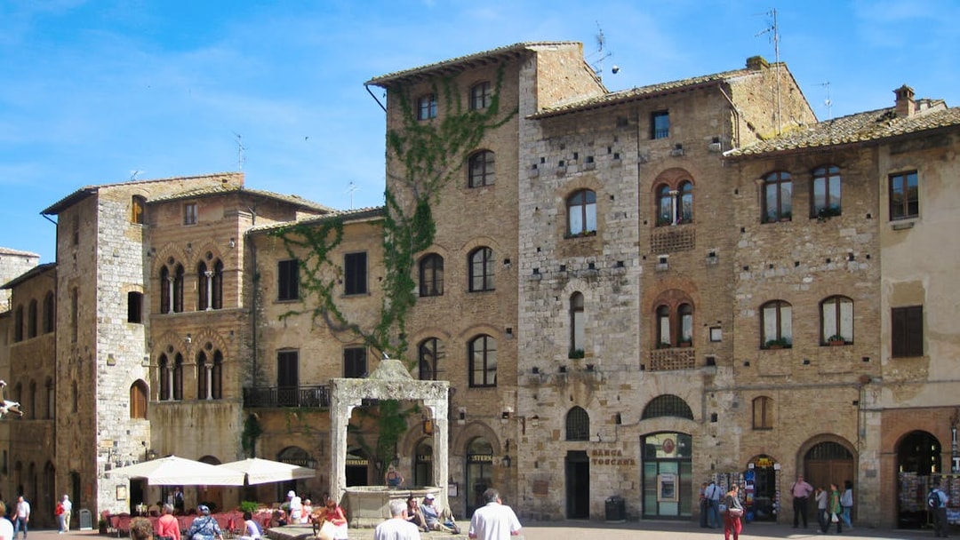San Gimignano town square with medieval buildings and tourists exploring.