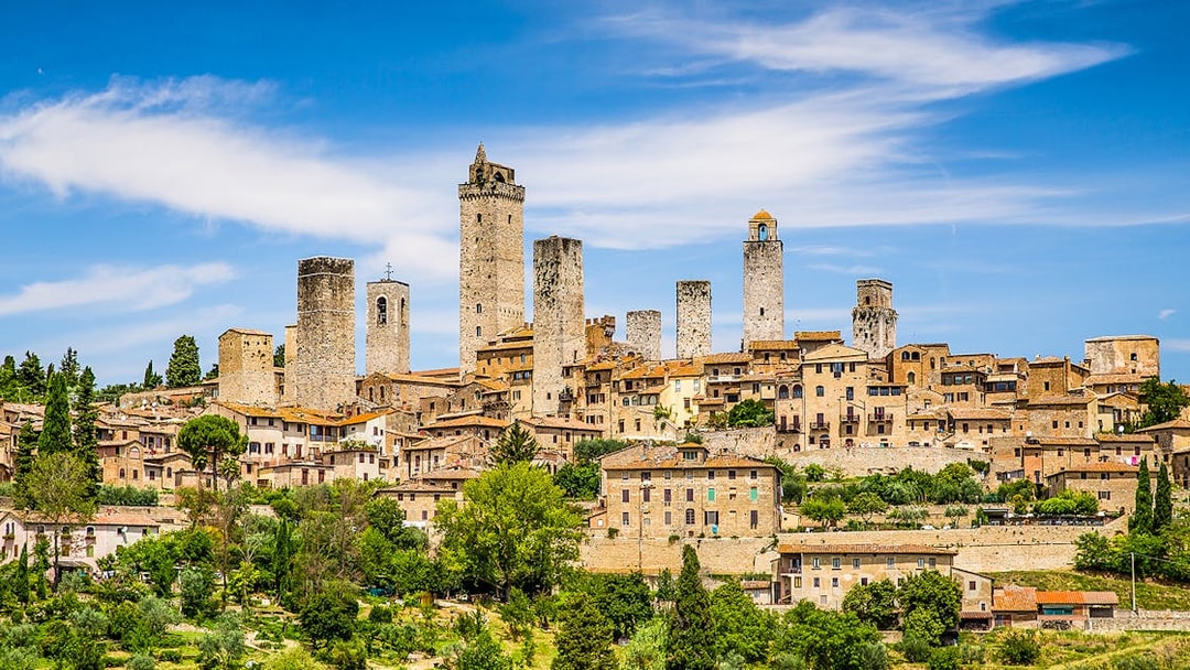 San Gimignano skyline with medieval towers under a blue sky, Tuscany, Italy.
