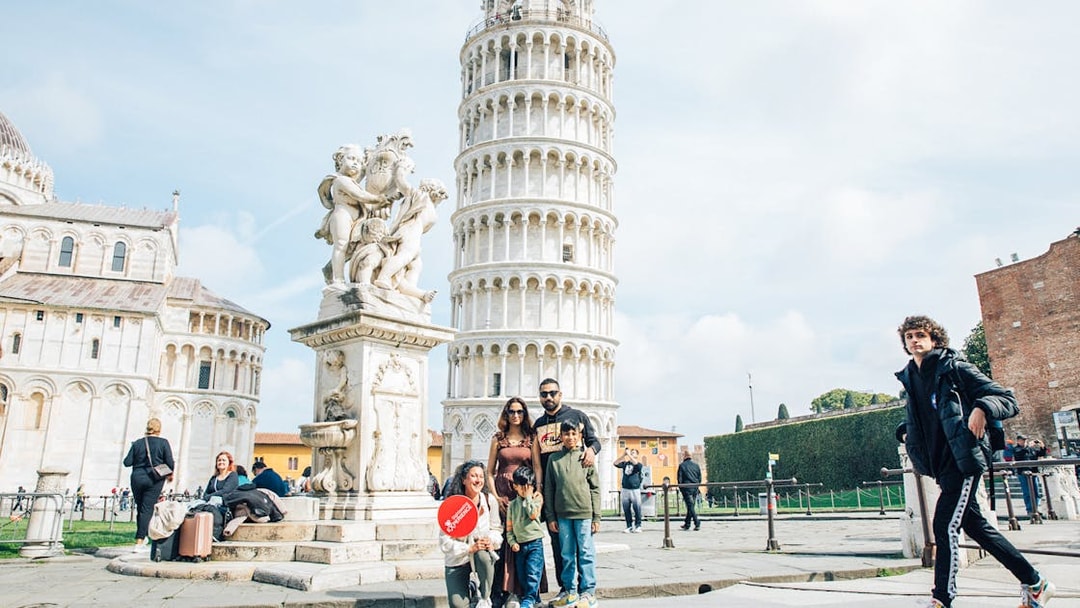 Tourists posing near the Leaning Tower of Pisa, Italy.