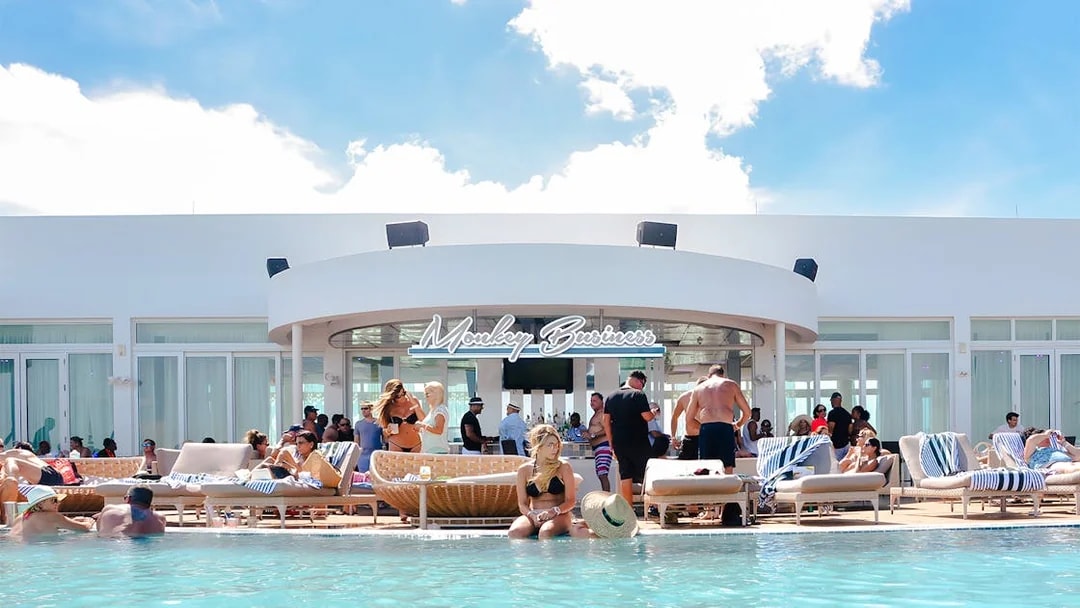 Poolside bar scene at Monkey Business in Bimini, Bahamas with people relaxing and socializing.