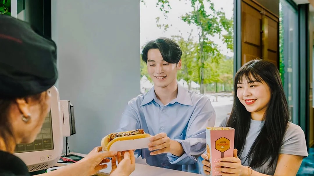 Happy couple receiving snacks at Gangchon Gimnyujeong Rail Bike experience.