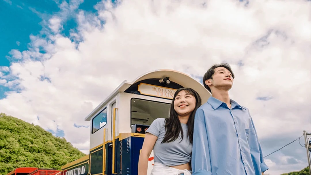 Couple enjoying Gangchon Gimnyujeong Rail Bike ride with scenic view.