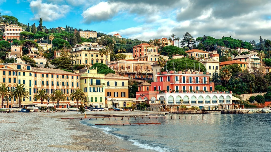 Colorful buildings along the coastline in Portofino, Italy, viewed from the beach.