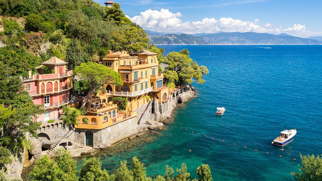 Bay of Portofino view with colorful villas and boats on a day trip from Genoa.
