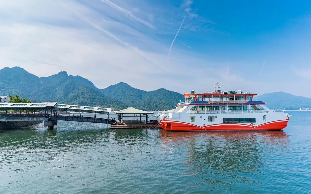 Ferry docked at Miyajima Island with mountains in the background, part of Hiroshima tour.