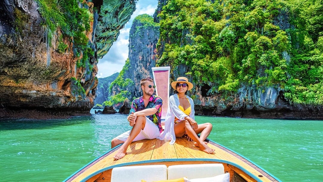 Longtailed boat tour through limestone cliffs in Krabi, Thailand.