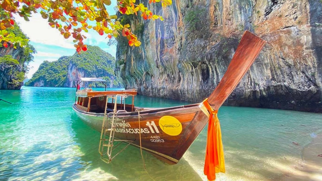 Longtail boat anchored near limestone cliffs in Krabi, Thailand, part of the 4 islands tour.