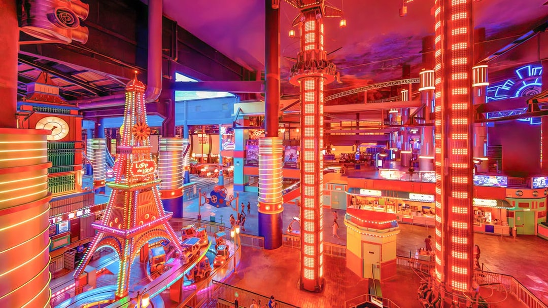 Colorful rides and attractions inside Skytropolis Indoor Theme Park, featuring neon lights and vibrant decor.