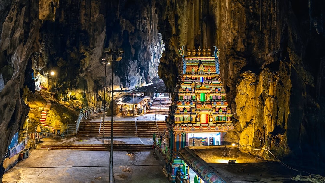 Hindu temple inside Batu Caves with colorful facade and rocky cave walls.