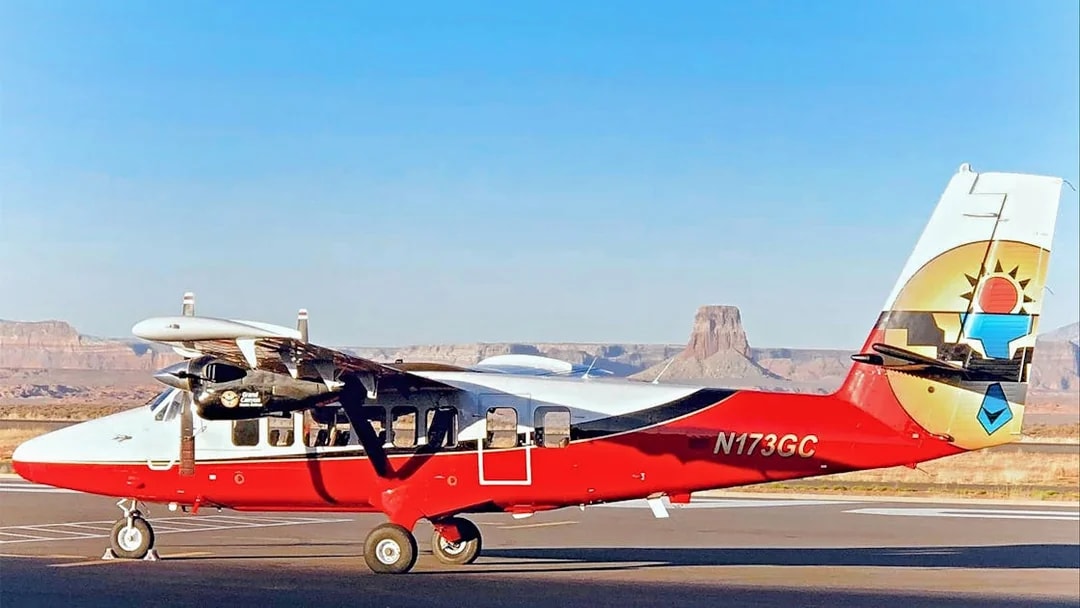 Small airplane on runway with Antelope Canyon and Horseshoe Bend in the background.