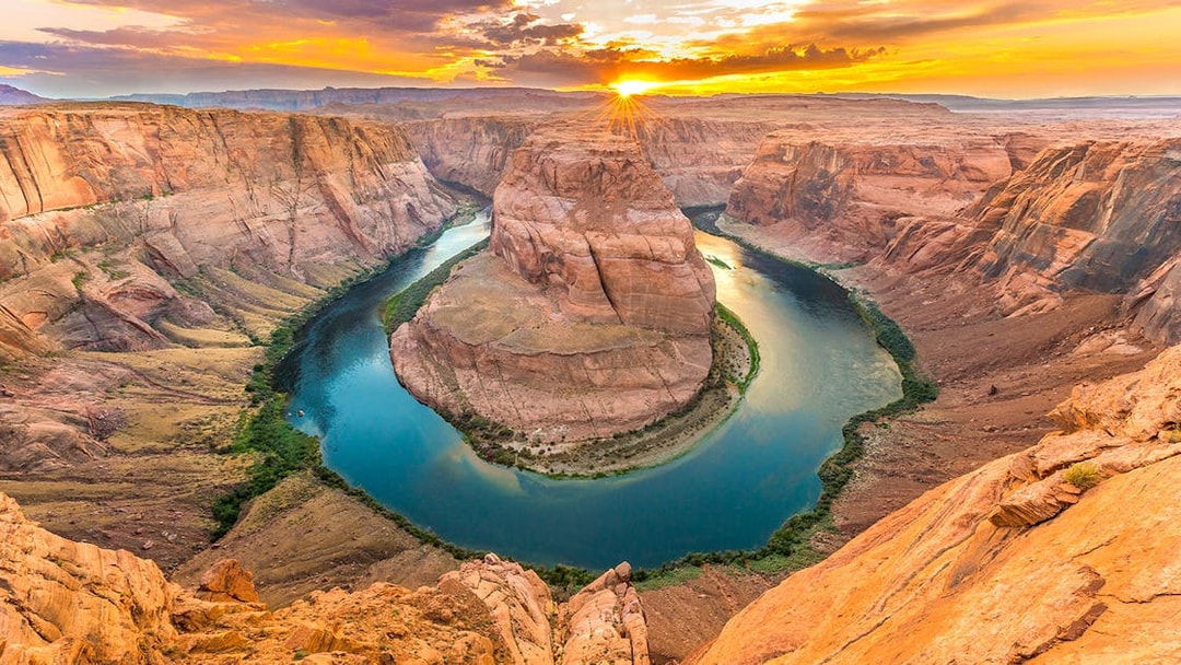 Aerial view of Horseshoe Bend at sunset, showcasing the Colorado River's curve in Arizona.