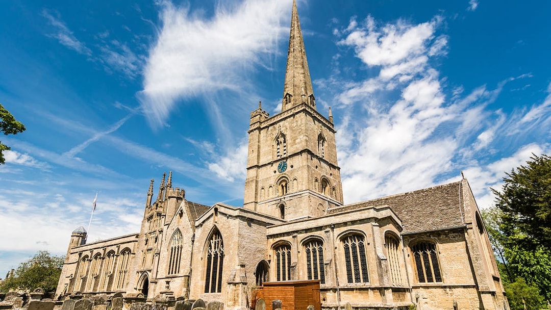 St. John the Baptist Church in Burford with its tall spire and historic architecture.
