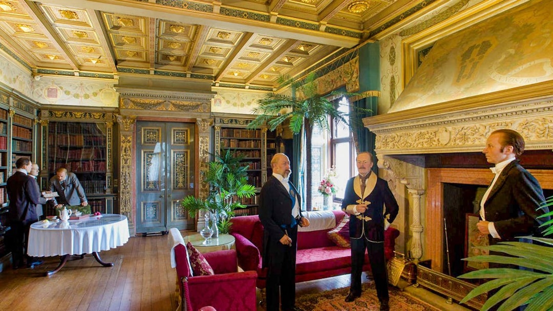 Warwick Castle interior with wax figures in period attire, showcasing historical decor.