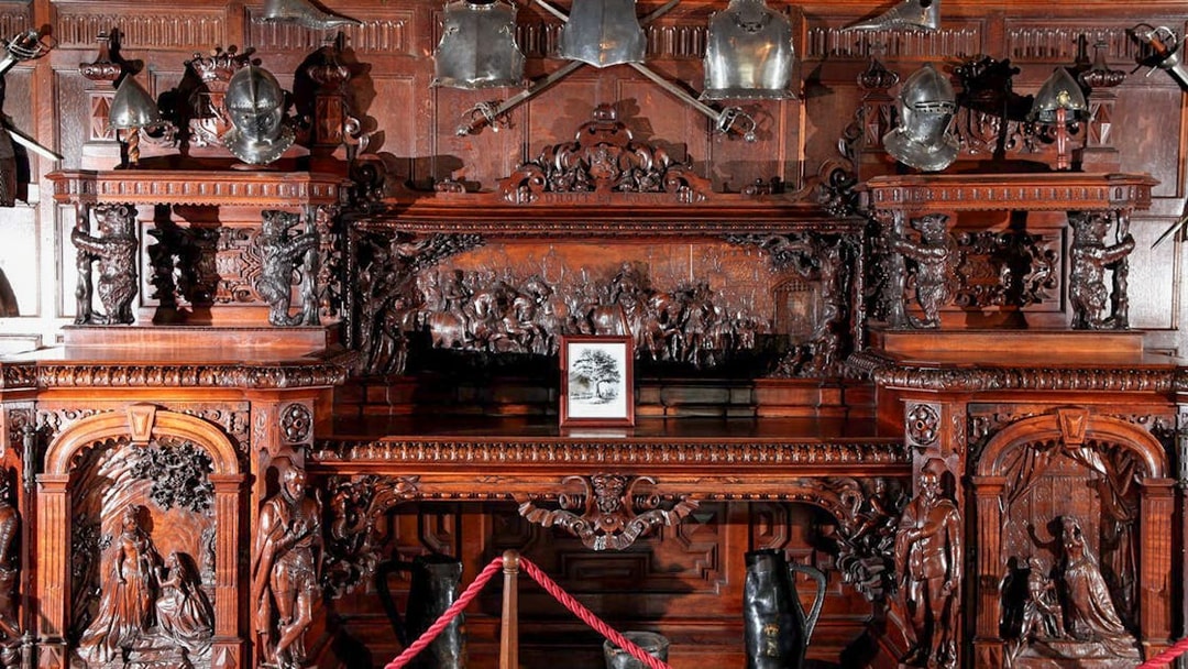 Ornate wooden carvings and medieval armor display at Warwick Castle.