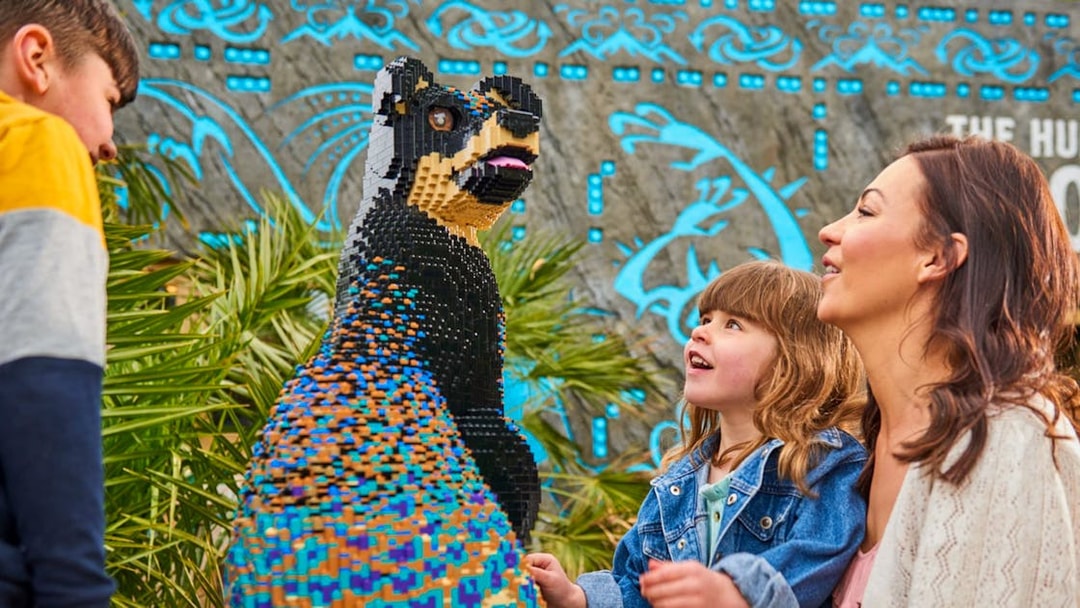 Child and adult admiring LEGO sculpture at LEGOLAND Windsor Resort.